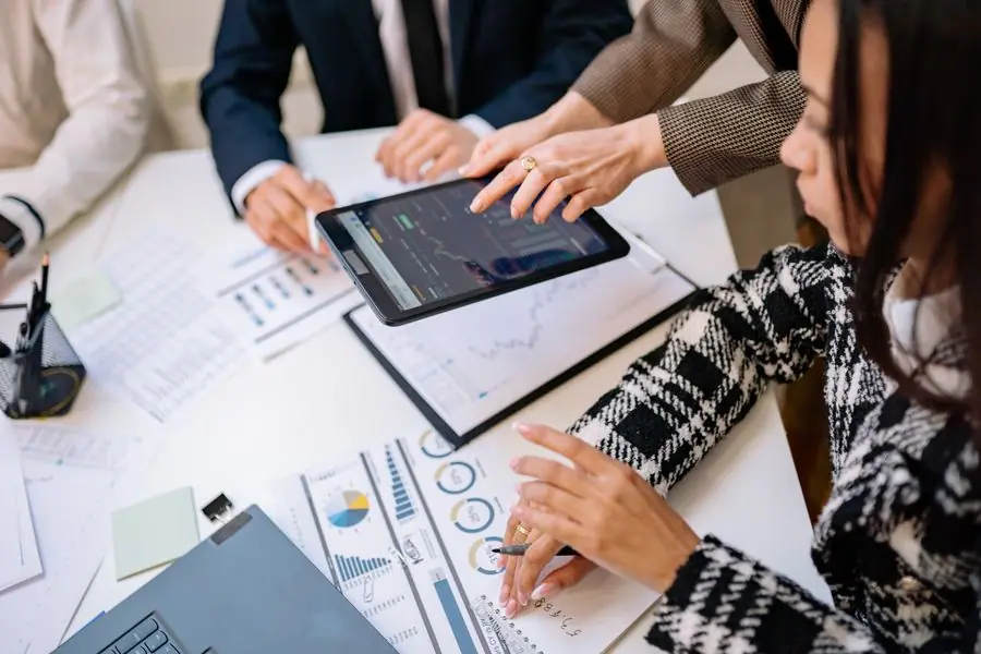 Equipo revisando indicadores en una tableta durante una reunión
